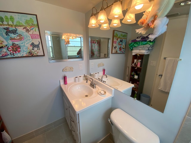 bathroom with a chandelier, vanity, tile patterned flooring, and toilet