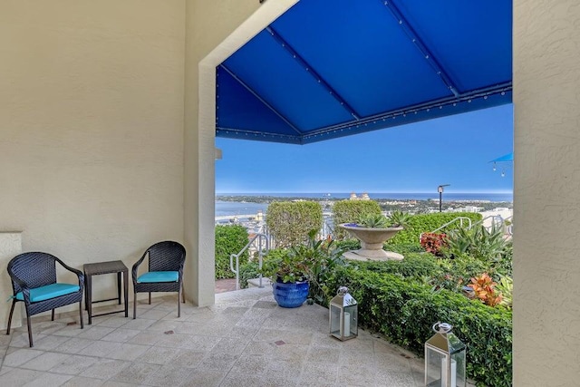 view of patio featuring a balcony and a water view