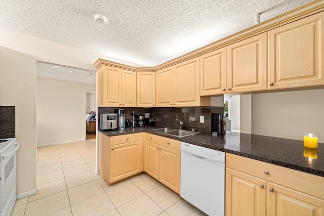 kitchen with dishwasher, stove, tasteful backsplash, sink, and light tile floors