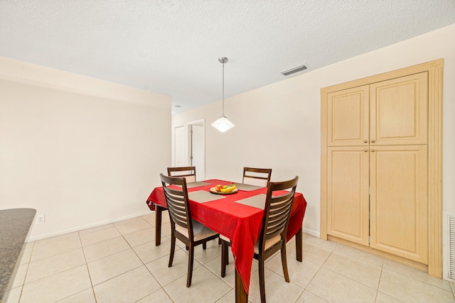 tiled dining room featuring a textured ceiling