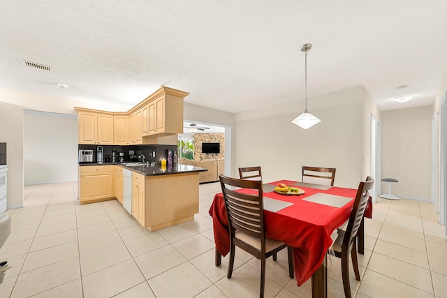 dining room with sink, a textured ceiling, and light tile flooring