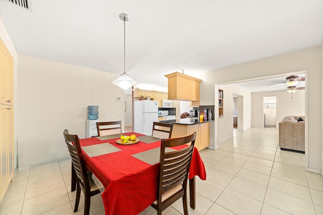 dining space featuring ceiling fan, a textured ceiling, and light tile flooring