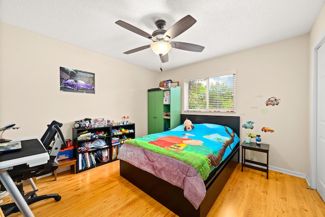 bedroom featuring light hardwood / wood-style floors, a textured ceiling, and ceiling fan