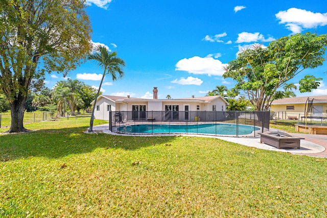 view of pool featuring a patio area, a yard, and an outdoor fire pit