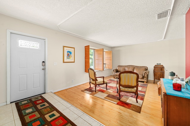 entrance foyer with a textured ceiling and light tile floors