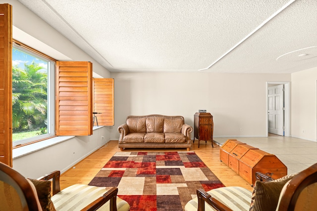 tiled living room featuring a wealth of natural light and a textured ceiling