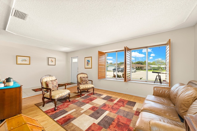 living room with hardwood / wood-style floors and a textured ceiling