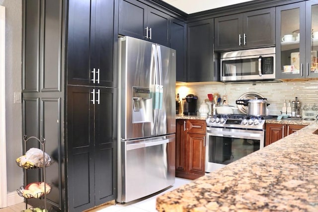 kitchen featuring appliances with stainless steel finishes, backsplash, light tile patterned floors, and light stone counters