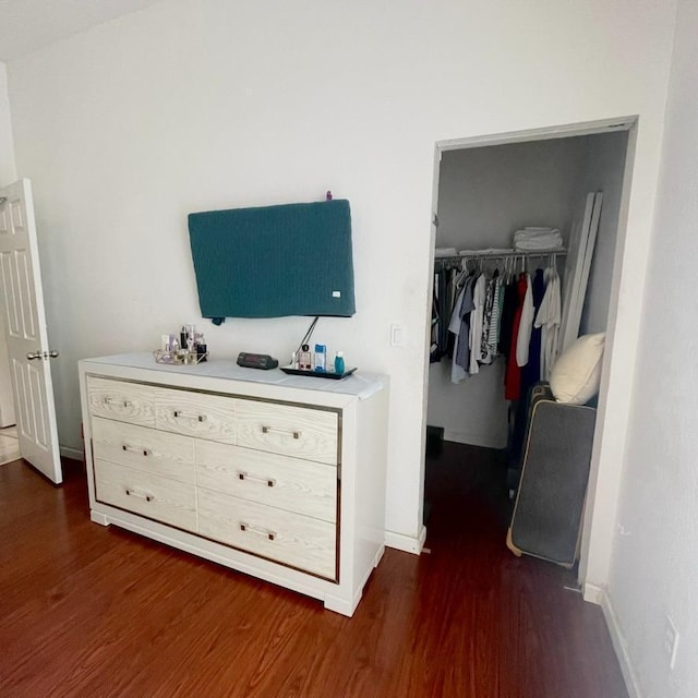 bedroom with dark wood-type flooring and a closet