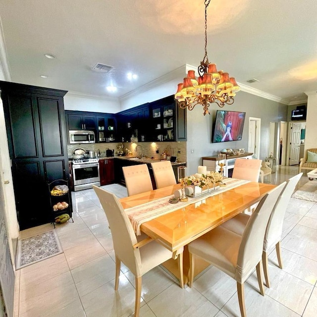 tiled dining area featuring a notable chandelier, crown molding, and sink