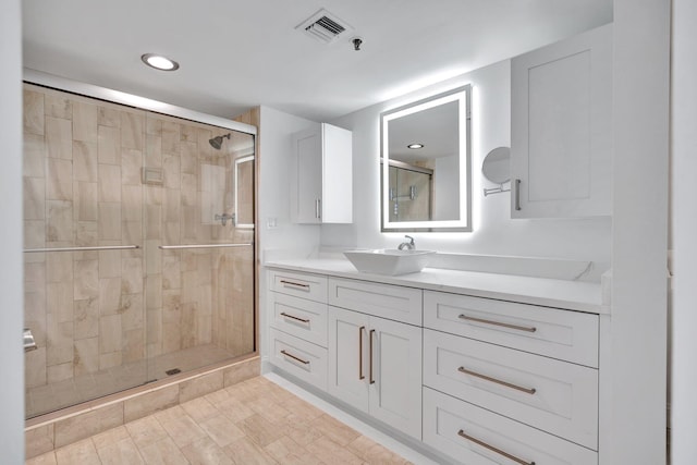 bathroom with walk in shower and vanity