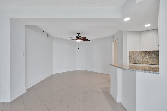 tiled spare room with ceiling fan