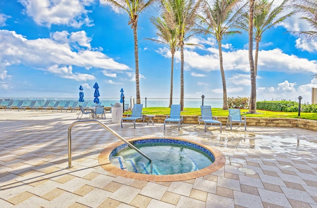 view of pool with a water view, a community hot tub, and a patio area