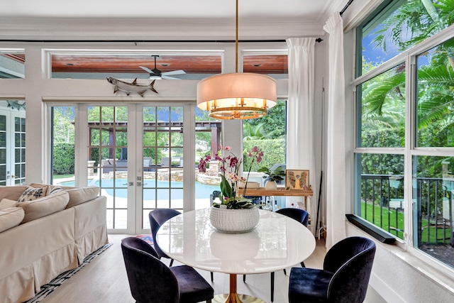 dining space featuring ornamental molding, french doors, and ceiling fan with notable chandelier