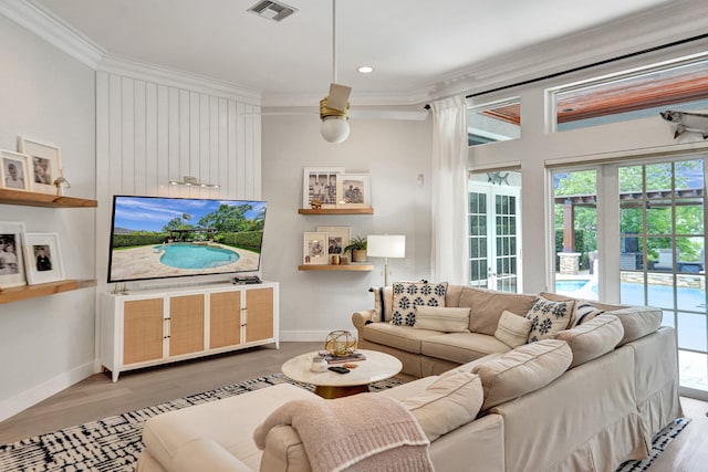 living room featuring ornamental molding, hardwood / wood-style flooring, a healthy amount of sunlight, and ceiling fan