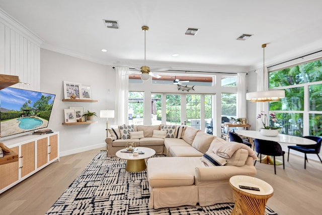 living room with ceiling fan with notable chandelier, crown molding, and light hardwood / wood-style flooring