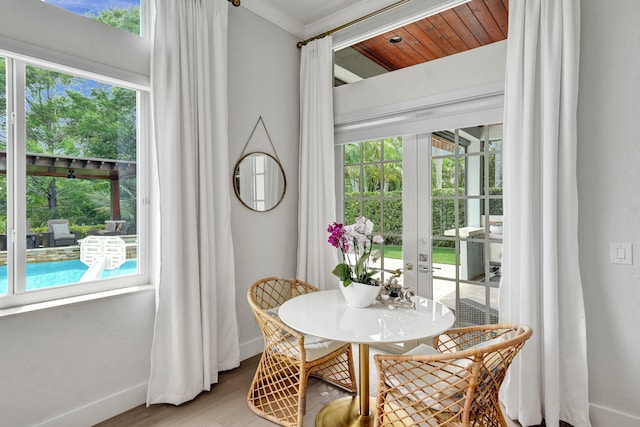 dining room with crown molding, wooden ceiling, wood-type flooring, and french doors