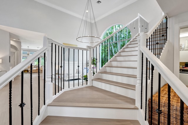 stairs with hardwood / wood-style floors and an inviting chandelier