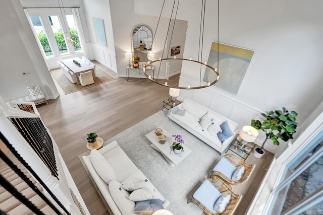 living room with a towering ceiling and wood-type flooring