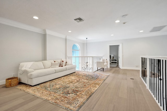 living room featuring a notable chandelier, crown molding, and light hardwood / wood-style flooring