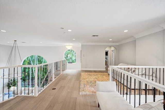 hallway featuring light wood-type flooring and crown molding