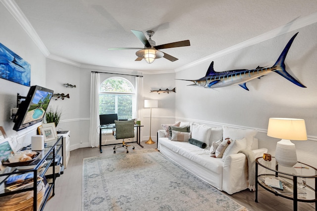 living room featuring ornamental molding, ceiling fan, hardwood / wood-style floors, and a textured ceiling