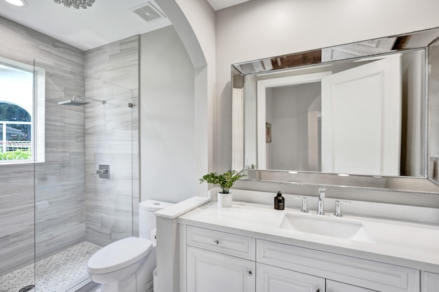 bathroom with an enclosed shower, vanity, and toilet