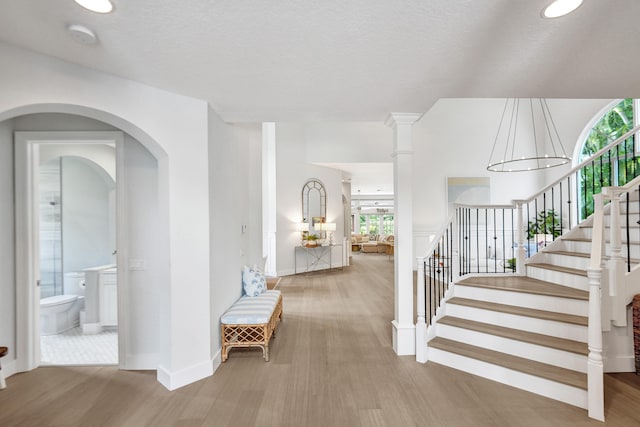 interior space with a wealth of natural light, hardwood / wood-style floors, an inviting chandelier, and a textured ceiling