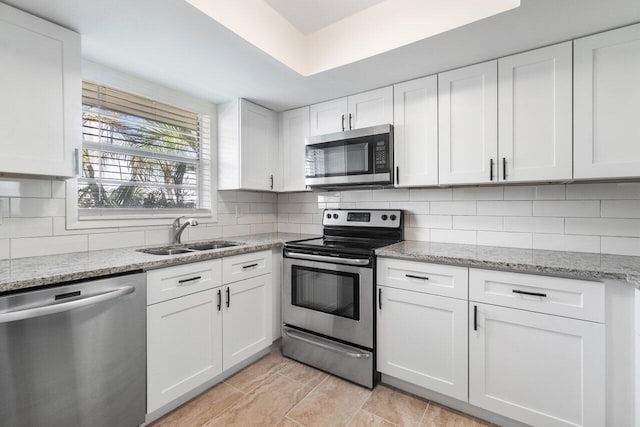 kitchen with stainless steel appliances, white cabinetry, and sink