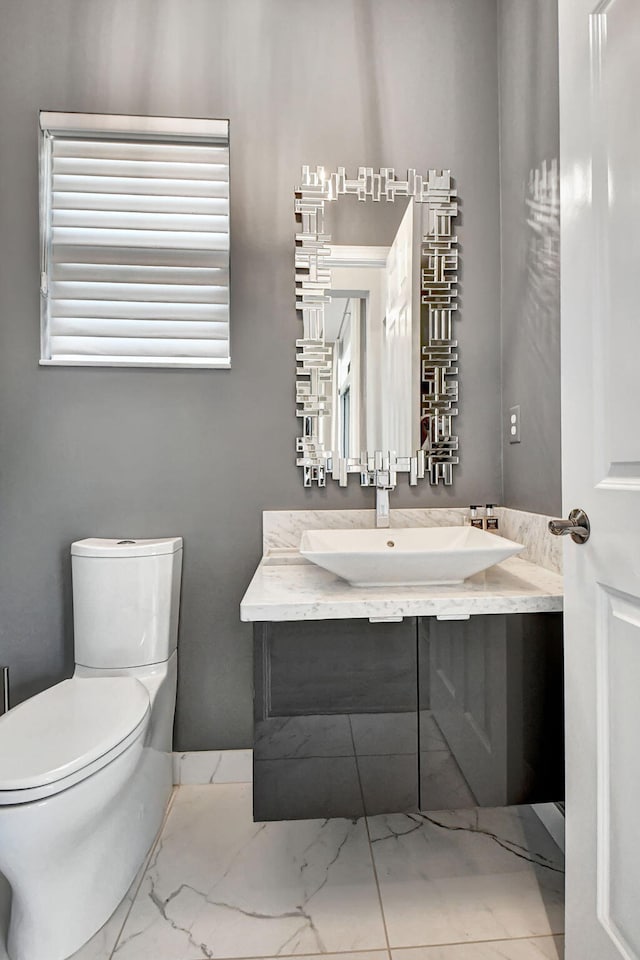 bathroom featuring tile floors, vanity with extensive cabinet space, and toilet