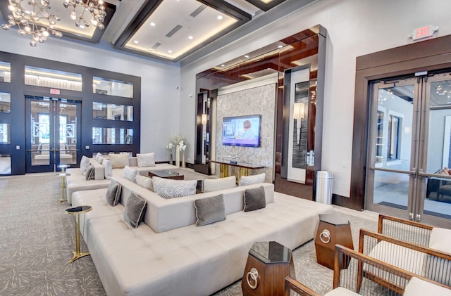 living room with carpet, a chandelier, a high ceiling, and french doors