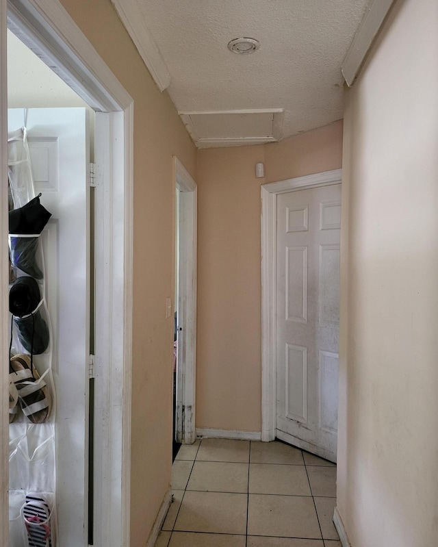 hall featuring a textured ceiling and light tile patterned floors