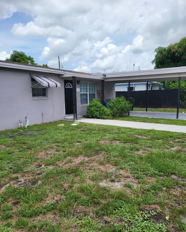 exterior space with a lawn and a carport