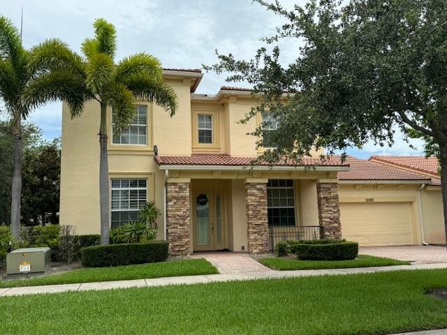 mediterranean / spanish-style home featuring a garage and a front yard