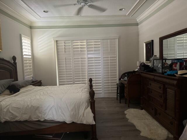 bedroom with ceiling fan, crown molding, and wood-type flooring