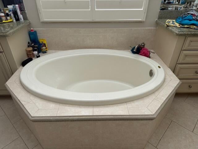 bathroom featuring tile flooring and tiled bath