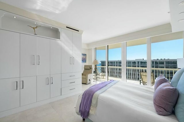 bedroom featuring floor to ceiling windows, light tile patterned floors, and access to outside