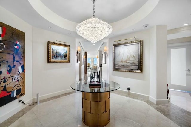 hall featuring a chandelier and a raised ceiling