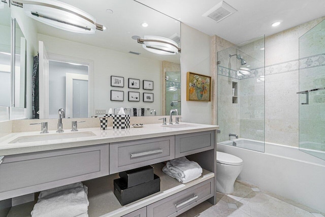 full bathroom with vanity, bath / shower combo with glass door, and toilet