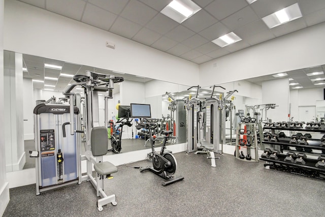 workout area with a drop ceiling and a towering ceiling