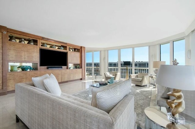 living room with built in shelves and floor to ceiling windows