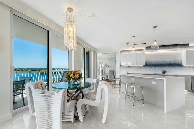 dining room featuring a water view, a chandelier, and sink