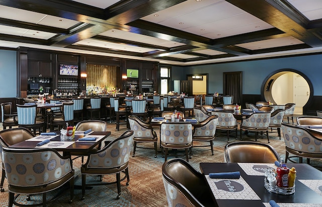 carpeted dining space with ornamental molding, beam ceiling, and coffered ceiling