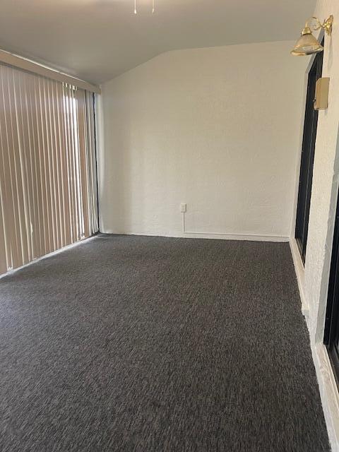 unfurnished room with dark colored carpet