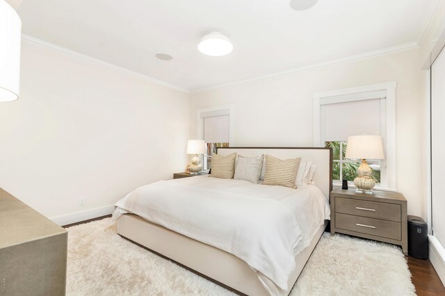 bedroom with crown molding and hardwood / wood-style floors