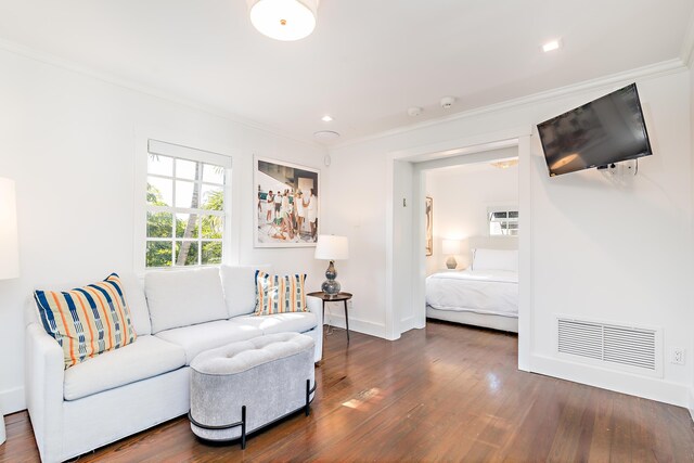 living room featuring dark hardwood / wood-style floors and ornamental molding