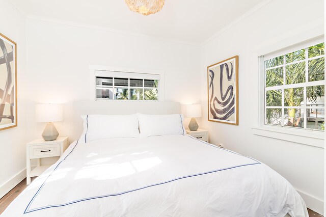 bedroom with wood-type flooring and ornamental molding