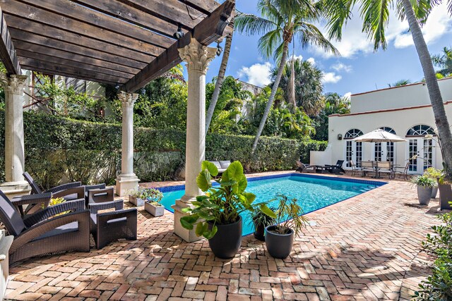 view of swimming pool featuring a pergola, a patio, and french doors