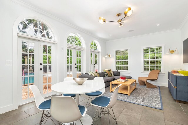 tiled dining space with french doors, a wealth of natural light, and ornamental molding