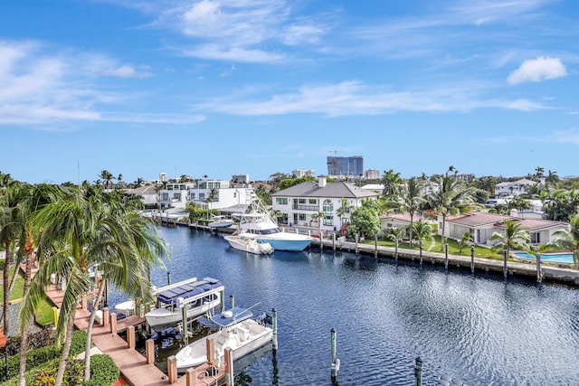 dock area featuring a water view, boat lift, and a residential view